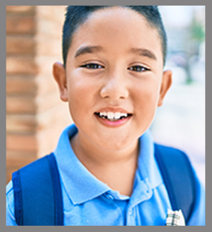 Elementary student smiling with his backpack on